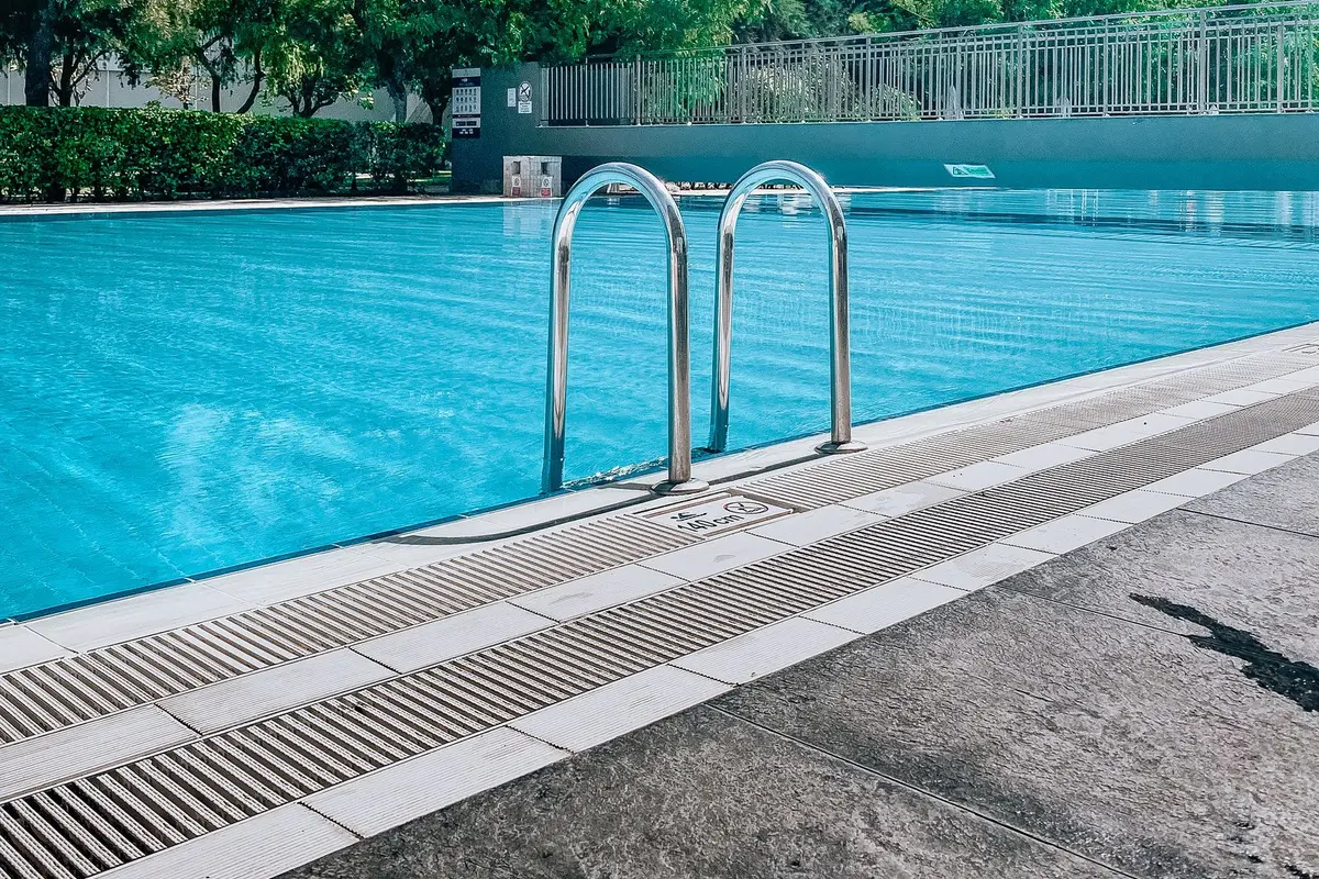 A large community pool with entry rails and clear water
